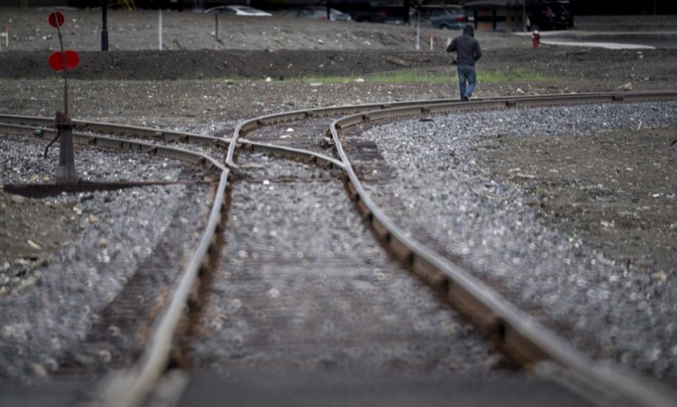 A man walks down the tracks in downtown Lac-Mégantic, Que., in 2014. THE CANADIAN PRESS/Paul Chiasson