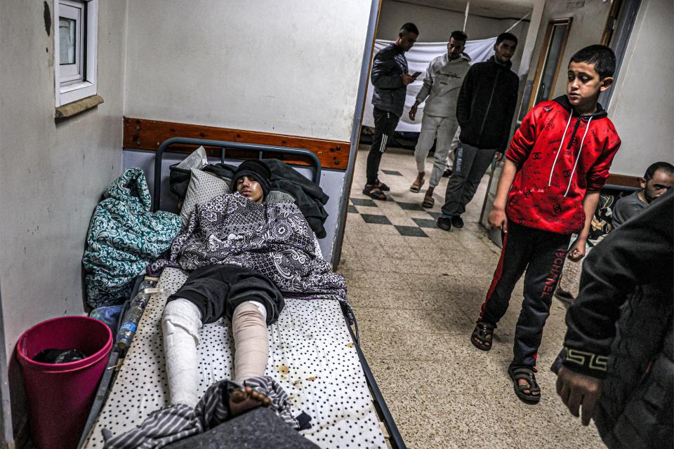 An injured youth lies on a bed at a makeshift camp in an area of the European Hospital in Khan Yunis in the southern Gaza Strip on Dec. 31, 2023, amid the ongoing conflict between Israel and the militant group Hamas.