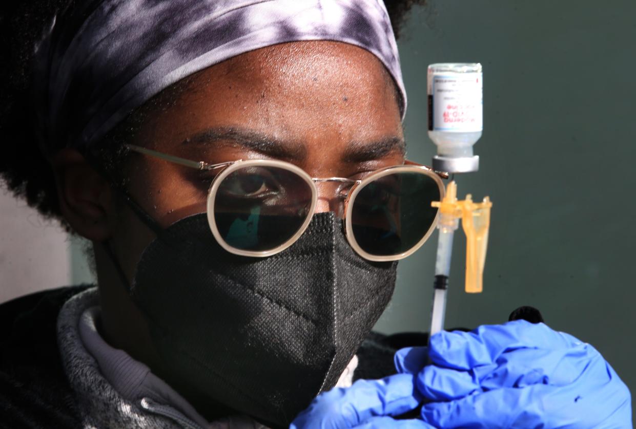 Nurse A.J. Delva draws a dose of COVID-19 vaccine during a sidewalk clinic set up by Eugene, Oregon, business woman Betty Snowden on Martin Luther King Jr. Day.