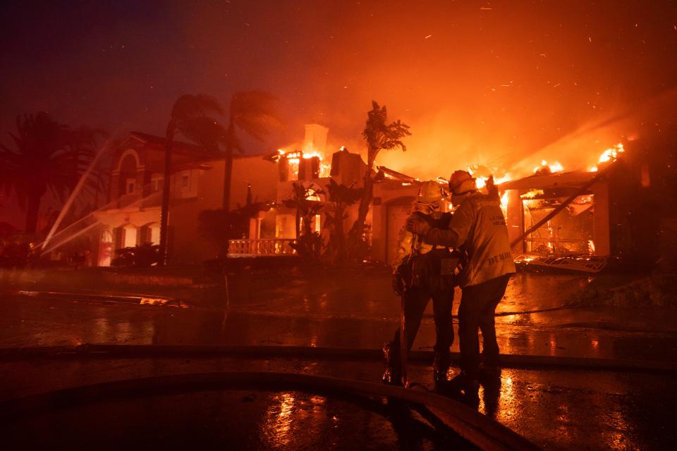 Firefighters battle home blazes last night in Laguna Niguel. Over 20 homes have been destroyed by a fire that started in the nearby canyon (EPA)