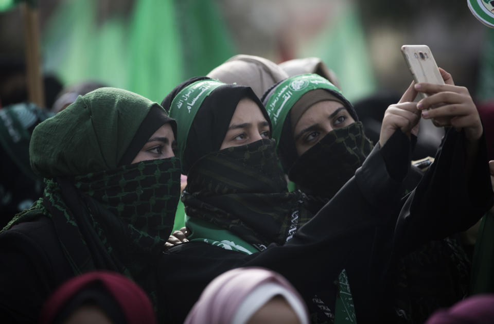 Women photograph take a selfie during a Hamas mass Rally marking the 31 anniversary of its founding, in Gaza City Sunday, Dec. 16, 2018. (AP Photo/Khalil Hamra)