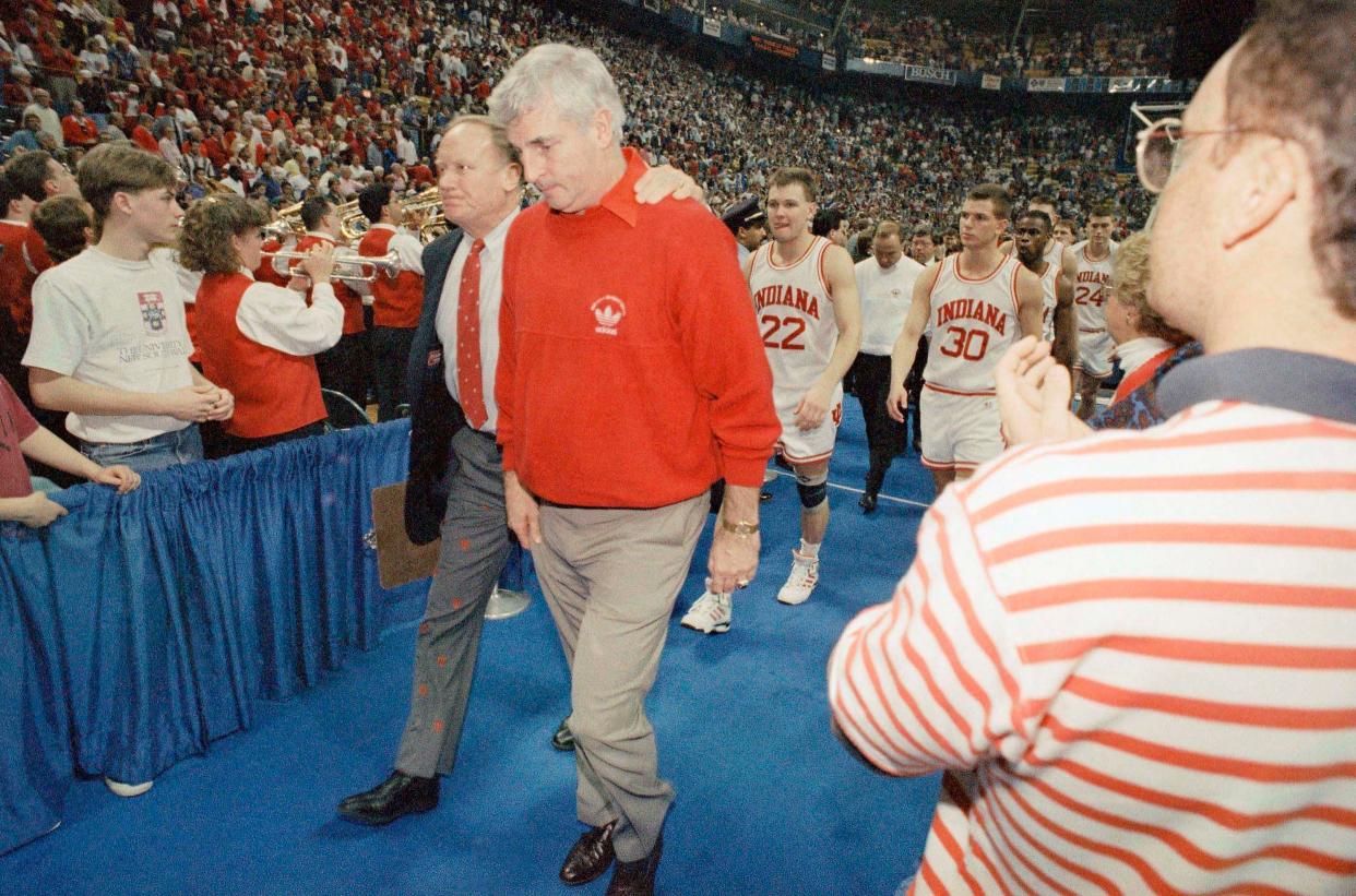 Indiana coach Bobby Knight, right, walks off the court with assistant coach Norm Ellenberger after Knights top-seeded Hoosiers lost to Kansas 83-77 in the NCAA Midwest Regional Championship game, March 27, 1993.