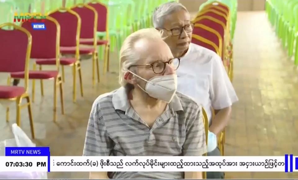 In this image taken from video by Myanmar state broadcaster MRTV, Australian Sean Turnell is shown seated during a ceremony inside the Insein prison in Yangon, Myanmar on Thursday, Nov. 17, 2022. Myanmar’s military-controlled government says it is releasing and deporting an Australian academic, a Japanese filmmaker, an ex-British diplomat and an American as part of a broad prisoner amnesty marking the country’s National Victory Day. (MRTV via AP)