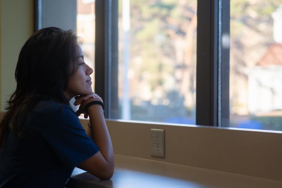 Peering out from the windows at Mabee Library at Washburn University Wednesday, senior Perla Soto says she often reflects on what brought her here as a first-generation student.