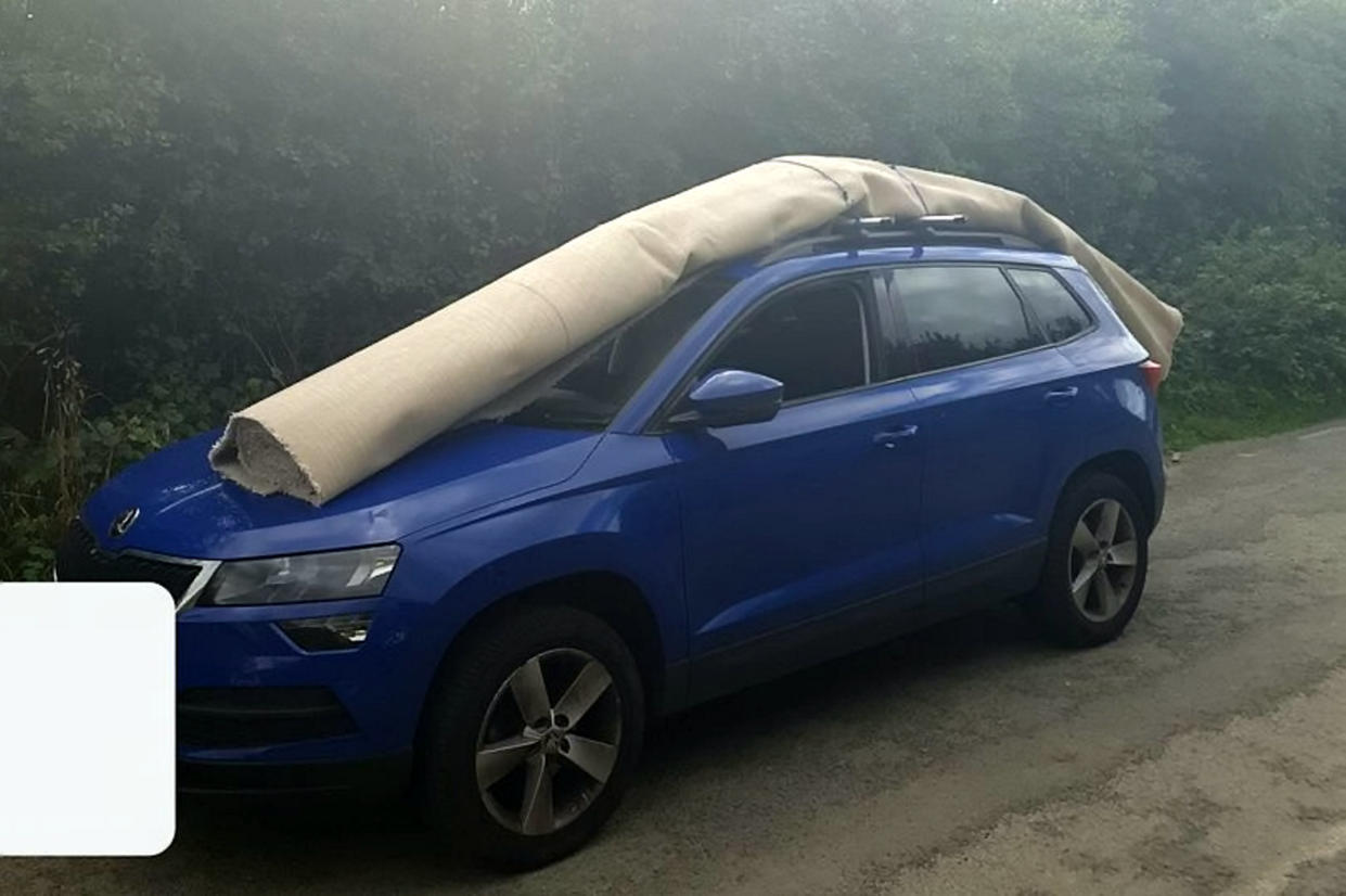 A driver was pulled over for carrying a rolled-up carpet on their roof and bonnet. (swns)