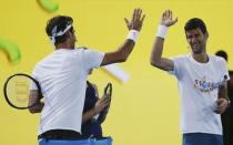 Switzerland's Roger Federer and Serbia's Novak Djokovic (R) react during a promotional event ahead of the Australian Open tennis tournament in Melbourne, Australia, January 14, 2017. REUTERS/Edgar Su