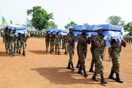 U.N. peacekeepers carry the coffins of the three United Nations soldiers from Bangladesh, who were killed by an explosive device in northern Mali on Sunday, during a ceremony at the MINUSMA base in Bamako, Mali September 27, 2017. REUTERS/Moustapha Diallo