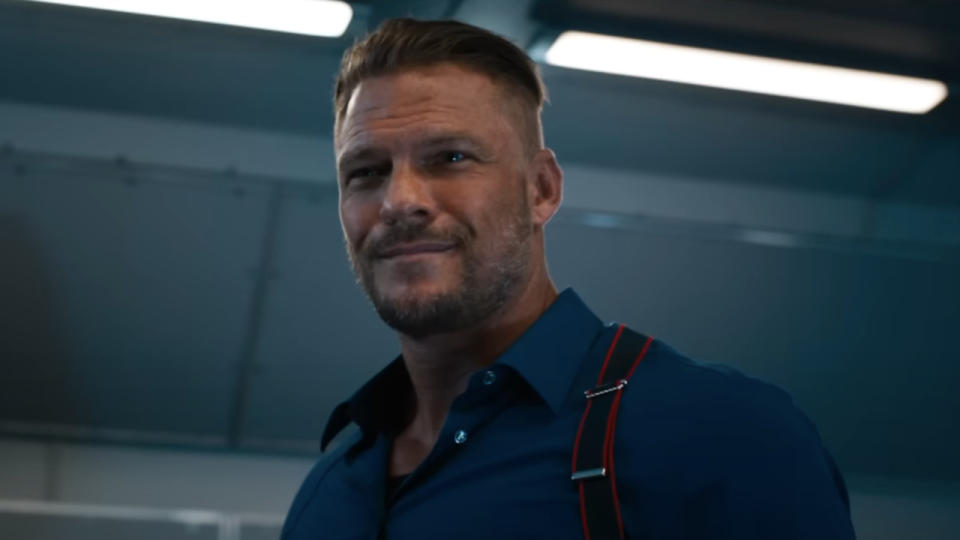 Alan Ritchson smiles while standing onboard of his spy plane in Fast X.