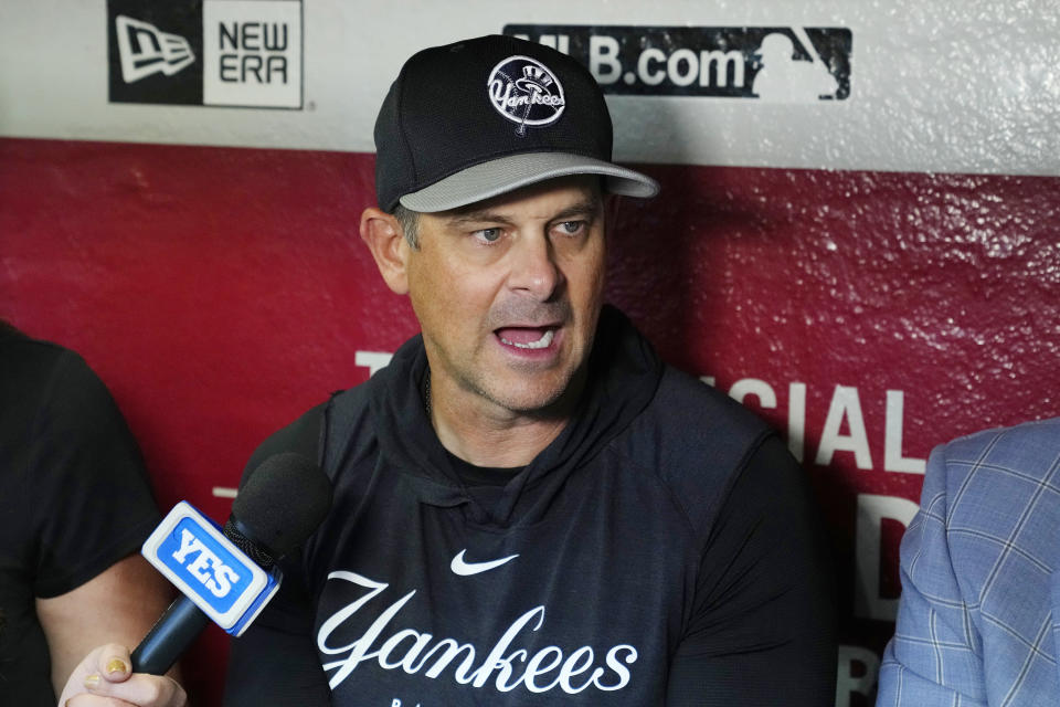 New York Yankees manager Aaron Boone speaks to reporters in the dugout prior to the team's baseball game against the Arizona Diamondbacks on Tuesday, April 2, 2024, in Phoenix. (AP Photo/Ross D. Franklin)