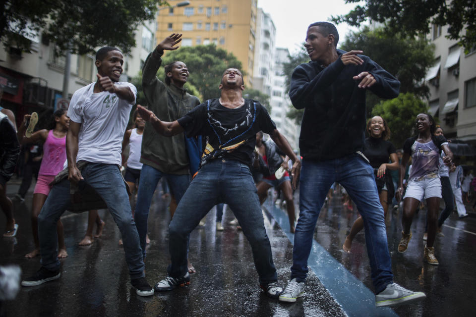 Friends and Residents of Pavao-Pavaozinho slum dance during a protest in the streets of Copacabana against the death of Douglas Rafael da Silva Pereira, after his burial in Rio de Janeiro, Brazil, Thursday, April 24, 2014. The protest followed the burial Pereira, whose shooting death sparked clashes Tuesday night between police and residents of the Pavao-Pavaozinho slum. (AP Photo/Felipe Dana)