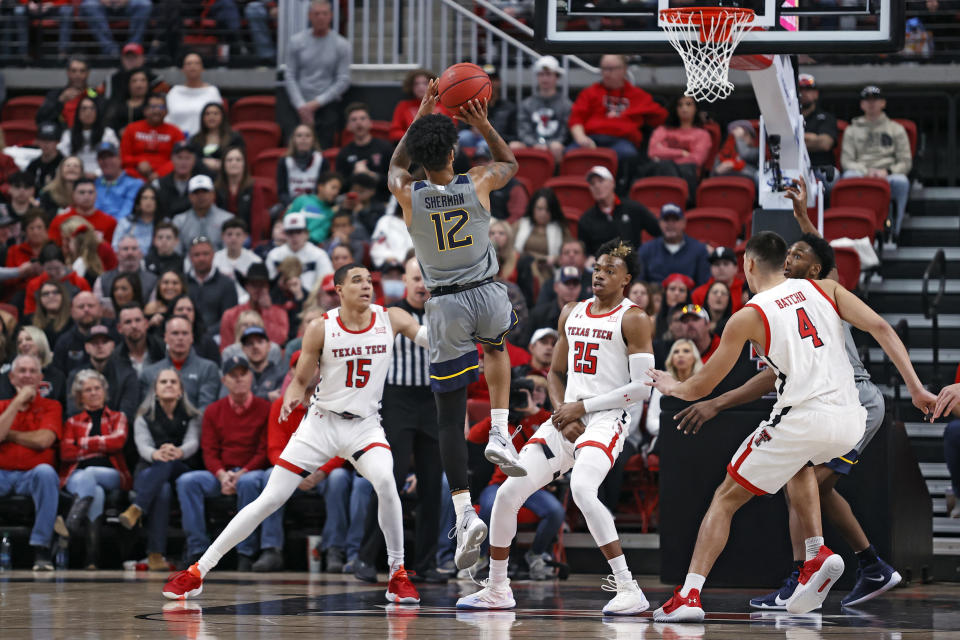 West Virginia's Taz Sherman (12) shoots the ball over Texas Tech's Adonis Arms (25) during the first half of an NCAA college basketball game on Saturday, Jan. 22, 2022, in Lubbock, Texas. (AP Photo/Brad Tollefson)