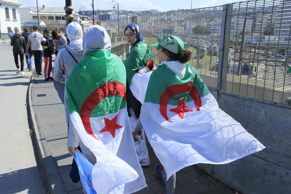Women wear the Algerian flag during a protest in Algiers, Friday, April 26, 2019. Algerians are massing for a 10th week of protests against their country's ruling class, calling for the ex-president's brother to be put on trial. (AP Photo/Anis Belghoul)
