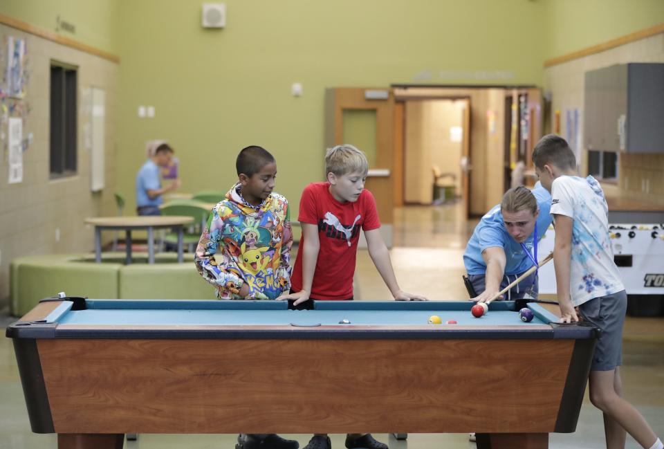 Youth Development Specialist Noah Kilgas plays pool with a group of boys in the games room at the Boys & Girls Club of Menasha Friday, August 11, 2023, in Menasha, Wis.