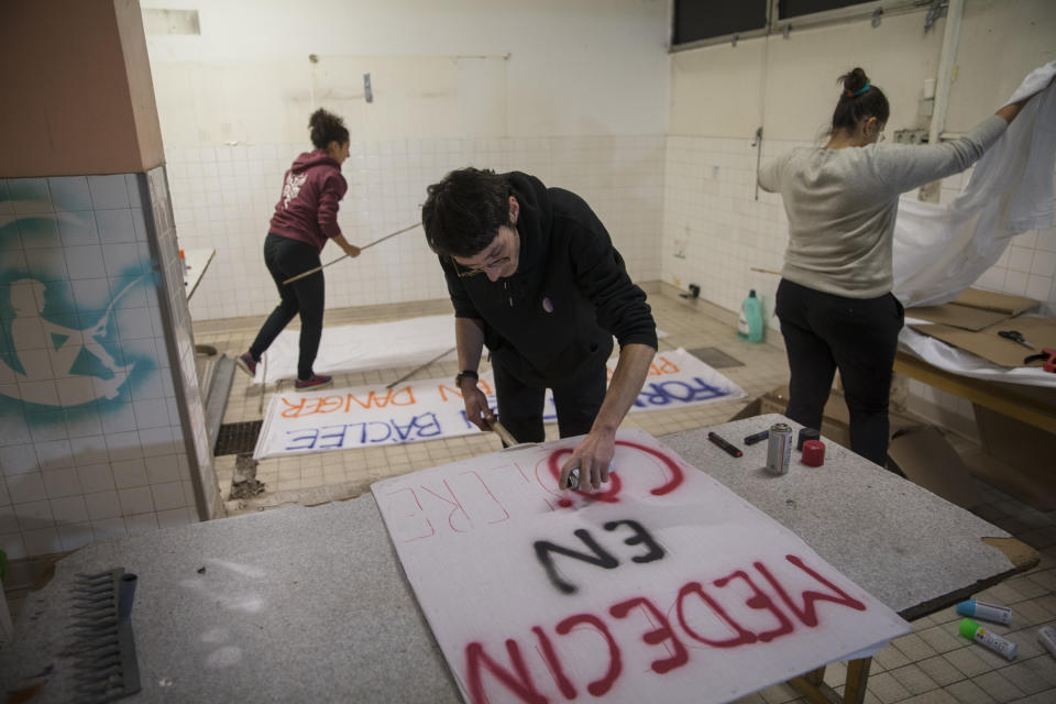 In this photo taken on Dec.9, 2019 Vincent Achour, a psychiatry intern and treasurer of the Autonomous Union for Interns of the Hospitals of Marseille, southern France, paints a sign that reads "doctors in anger" before a intern march to raise awareness about their strike. In a hospital in Marseille, student doctors are holding an exceptional, open-ended strike to demand a better future. France’s vaunted public hospital system is increasingly stretched to its limits after years of cost cuts, and the interns at La Timone - one of the country’s biggest hospitals - say their internships are failing to prepare them as medical professionals. Instead, the doctors-in-training are being used to fill the gaps. (AP Photo/Daniel Cole)