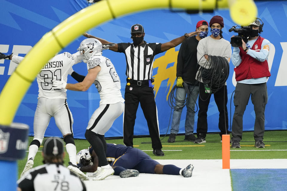 Los Angeles Chargers wide receiver Mike Williams, below, stays down on the field after an injury and an incomplete pass in the end zone during the second half of an NFL football game against the Las Vegas Raiders, Sunday, Nov. 8, 2020, in Inglewood, Calif. (AP Photo/Ashley Landis)