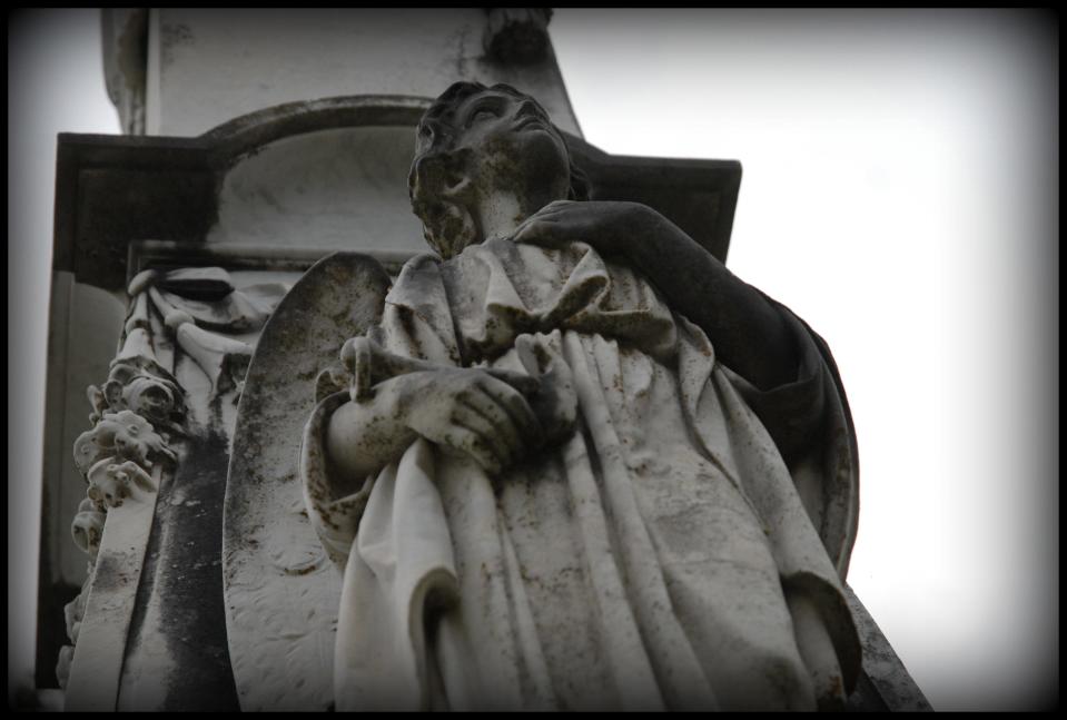 Ornately-detailed statues decorate some of the larger burial vaults at Cedar Grove, rising up above the cemetery's more earthbound graves sites.