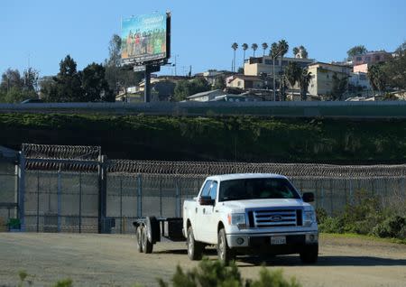 A maintenance worker passes through a gate from a secure zone between Tijuana, Mexico and the United States in San Ysidro, California, U.S., January 25, 2017. REUTERS/Mike Blake