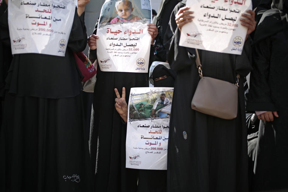 FILE - In this Dec. 10, 2018 file photo, Yemeni women hold banners in Arabic that read, in part, "Open Sanaa airport to limit the suffering and deaths," "Medicine is life," and Open Sanaa airport to receive medical aide," as they take part in a protest calling for the reopening of the airport in Sanaa to receive medical aid, in front of the U.N. offices in Sanaa, Yemen. An Associated Press investigation found some of the United Nations aid workers sent in to Yemen amid a humanitarian crisis caused by five years of civil war have been accused of enriching themselves from an outpouring of donated food, medicine and money. (AP Photo/Hani Mohammed, File)