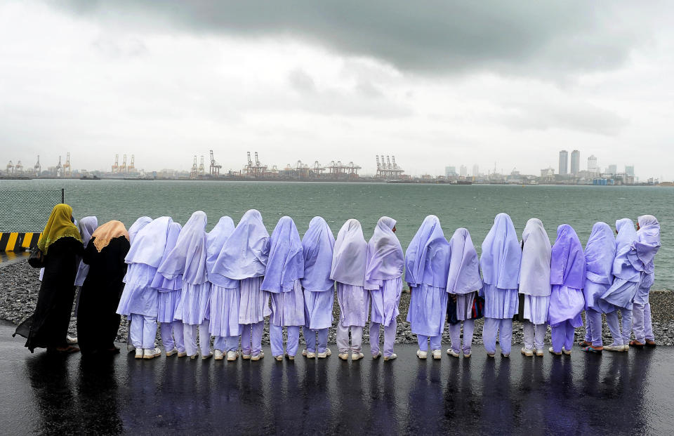 Sri Lankan Muslim school girls stand on the edge of a sea port in Colombo on May 20, 2013, after traveling from their town of Kalmunai, over 231 miles away.&nbsp;