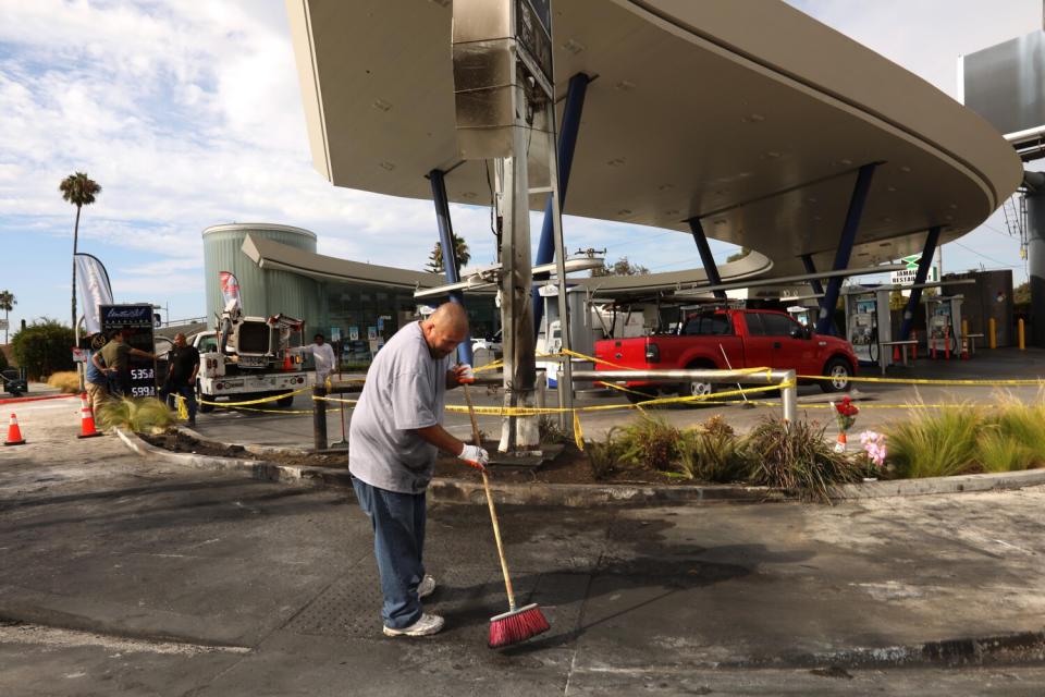 A worker sweeps with a broom.