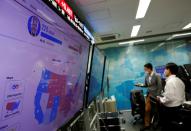 Employees of the foreign exchange trading company Gaitame.com work in front of a monitor showing news on the 2020 U.S. presidential election at a dealing room in Tokyo