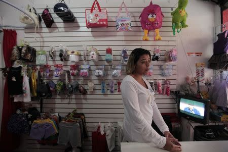 Valeria Rocha talks to Reuters in her store at Jardim Sao Luis, near the edge of Sao Paulo August 28, 2014. REUTERS/Paulo Whitaker