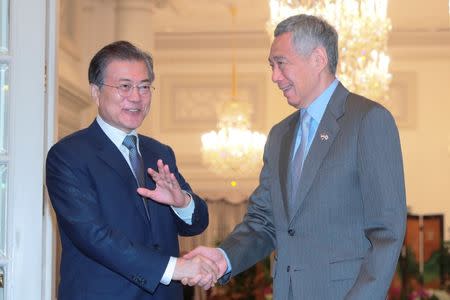 South Korea's President Moon Jae-in shakes hands with Singapore's Prime Minister Lee Hsien Loong during a visit at the Istana in Singapore July 12, 2018. Wallace Woon/Pool via REUTERS