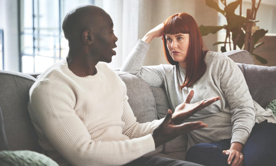 A couple having a serious discussion on the couch