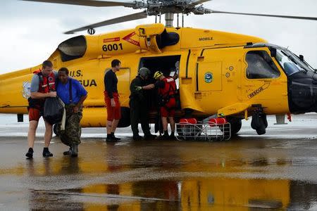 Evacuees leave a U.S. Coast Guard helicopter after being rescued from flooding due to Hurricane Harvey in Houston, Texas, August 27, 2017.U.S. Coast Guard/Petty Officer 3rd Class Johanna Strickland/Handout via REUTERS