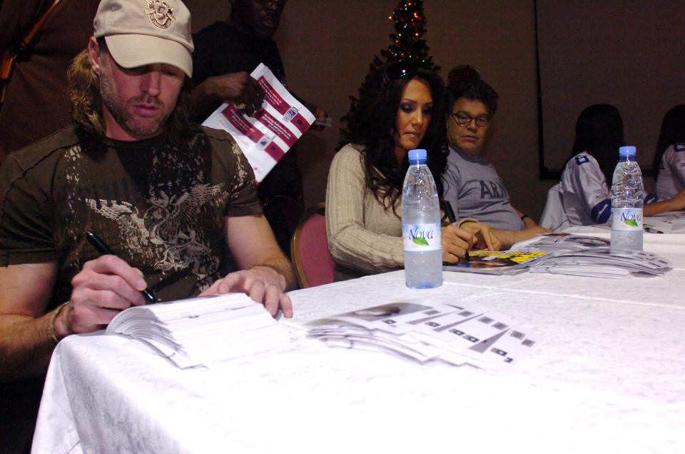 From left to right, musician Darryl Worley, sportscaster Leeann Tweeden and comedian Al Franken greet soldiers during an autograph session in Kuwait, Dec. 14, 2006. (Photo: Sgt Thomas Day/DVIDS)