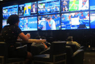 A gambler watches sporting events on large screens at the FanDuel sportsbook in East Rutherford N.J. on Aug. 30, 2021. The American Gaming Association says 45.2 million Americans plan to bet on NFL games this season, up 36% from last year. (AP Photo/Wayne Parry)