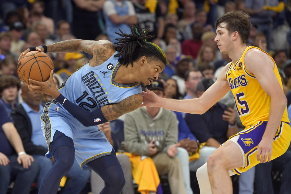 Memphis Grizzlies guard Ja Morant (12) keeps the ball from Los Angeles Lakers guard Austin Reaves (15) during the second half of Game 5 in a first-round NBA basketball playoff series Wednesday, April 26, 2023, in Memphis, Tenn. (AP Photo/Brandon Dill)