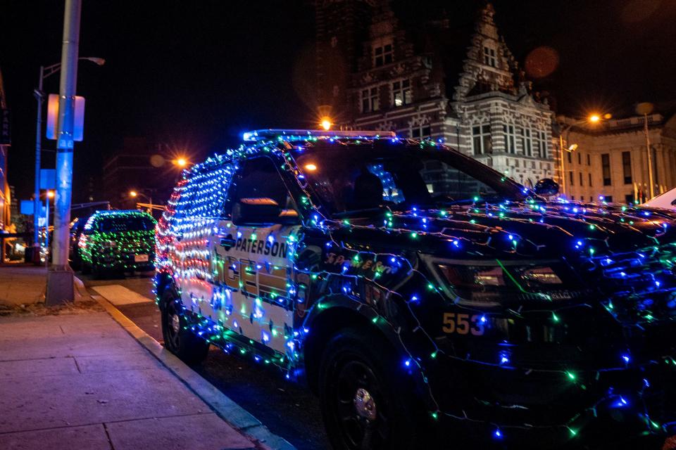 The Paterson Police Department is using a grant to give gift cards to families at the Center City Mall in Paterson, NJ on Wednesday, Dec. 21, 2022. Festively decorated police cars sit outside Center City Mall. 