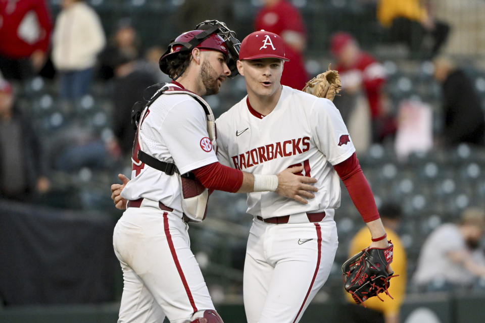 FILE - Arkansas catcher Parker Rowlan, left, and pitcher Dylan Carter, right, celebrate after defeating Louisiana Tech 7-4 during an NCAA Baseball game on Friday, March 10, 2023, in Fayetteville, Ark. The SEC-favorite Razorbacks enter most years as a national title contender, and this year's roster gives them their best chance at the program's first championship since the 2018 team came within a dropped foul ball of winning it all.(AP Photo/Michael Woods, File)