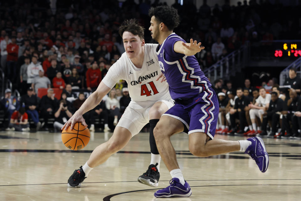 Cincinnati's Simas Lukosius, left, tries to dribble past TCU's Trevian Tennyson during the first half of an NCAA college basketball game Tuesday, Jan. 16, 2024, in Cincinnati. (AP Photo/Jay LaPrete)