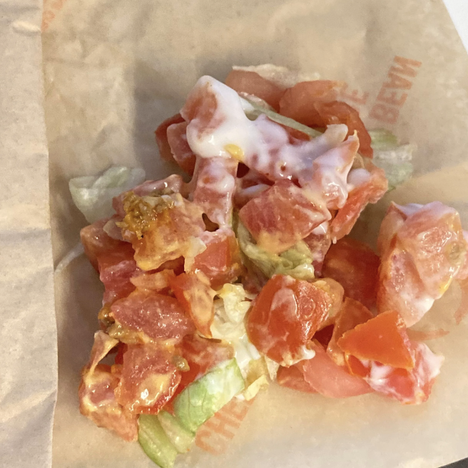 Salad with chopped tomatoes and lettuce on a paper wrap