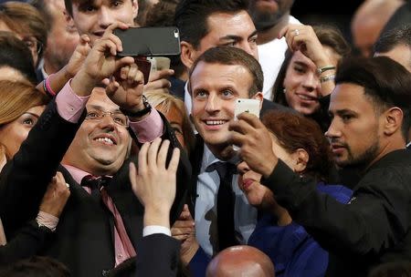 Former French economy minister Emmanuel Macron takes selfies with supporters at the end of his rally for his political movement, En Marche !, or Forward !, in Montpellier, France, October 18, 2016. REUTERS/Jean-Paul Pelissier