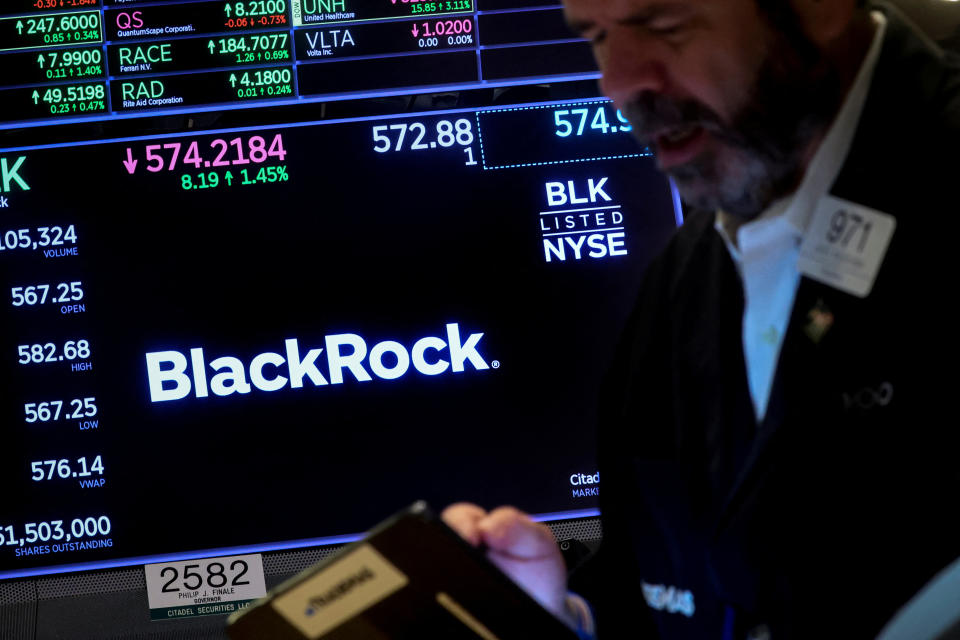 A trader works as a screen displays the trading information for BlackRock on the floor of the New York Stock Exchange (NYSE) in New York City, U.S., October 14, 2022. REUTERS/Brendan McDermid