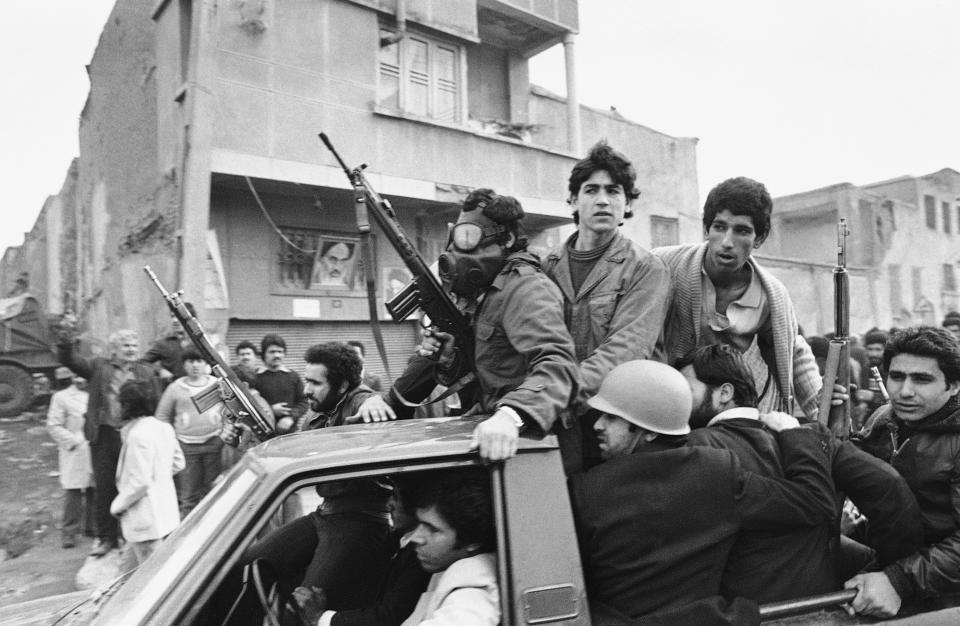 FILE - In this Feb. 12, 1979 file photo, armed rebels, one wearing a gas mask, ride in a truck near the headquarters of Ayatollah Khomeini in Tehran, Iran. Forty years ago, Iran's ruling shah left his nation for the last time and an Islamic Revolution overthrew the vestiges of his caretaker government. The effects of the 1979 revolution, including the takeover of the U.S. Embassy in Tehran and ensuing hostage crisis, reverberate through decades of tense relations between Iran and America. (AP Photo/Campion, File)