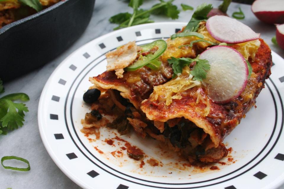 Vegan enchiladas stuffed with kale, black bean, and shredded sweet potatoes.