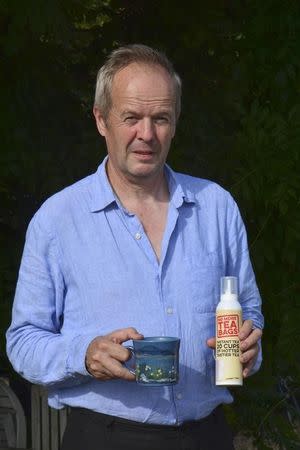 Guy Woodall, the owner of Yum Cha Drinks, poses with a cup of tea and a No More Tea Bags aerosol can, in Leatherhead, Britain, September 14, 2016. Picture taken September 14, 2016. REUTERS/Matthew Stock
