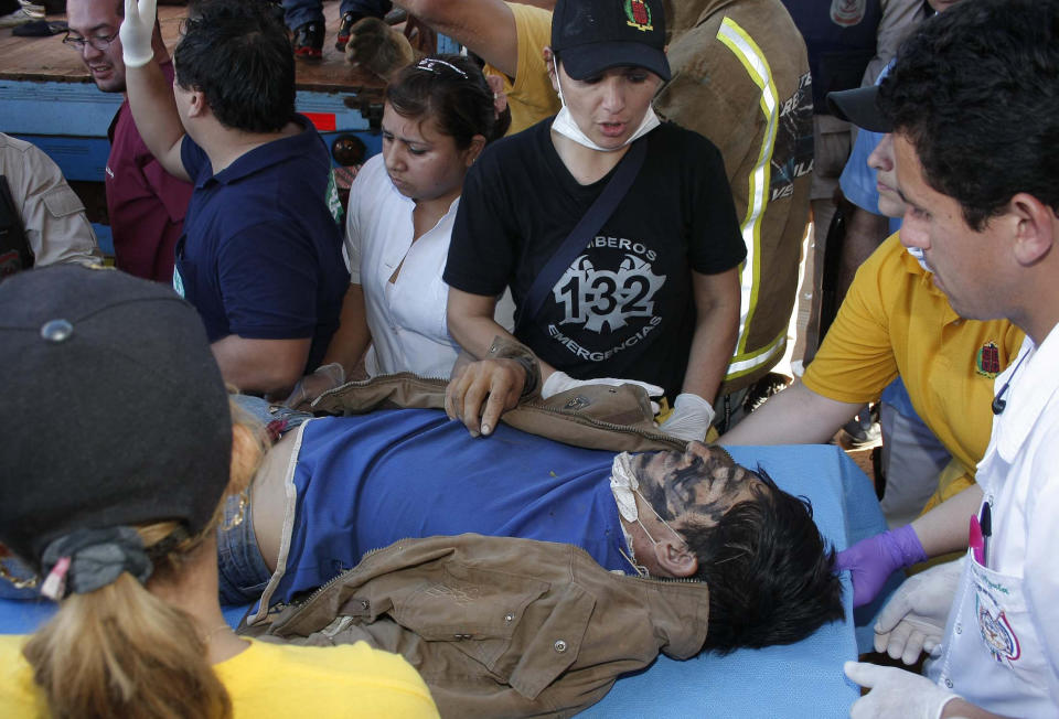 A farmer wounded in a land dispute is carried on a gurney to a nearby hospital, in Curuguaty, Paraguay, Friday, June 15, 2012. Paraguay deployed its army on Friday to resolve the violent land dispute in Curuguaty, a remote northern forest reserve, where 17 people have been killed in gun battles between police and landless farmers when police were trying to evict about 150 farmers from the reserve, which is part of a huge estate owned by a Colorado Party politician opposed to leftist President Fernando Lugo. (AP Photo)