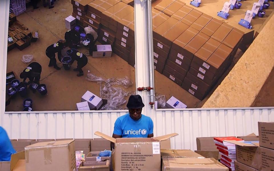 People work inside the Unicef warehouse, the world's largest humanitarian aid warehouse, in Copenhagen  - AP