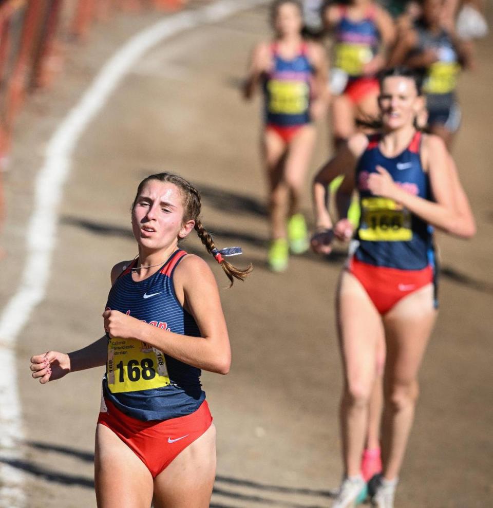 Buchanan girls cross country runners, including Stefania Seasick, left, come down the hill still grouped together after the 2-mile mark in the girls Division I state cross country championships at Woodward Park in Fresno on Saturday, Nov. 25, 2023.