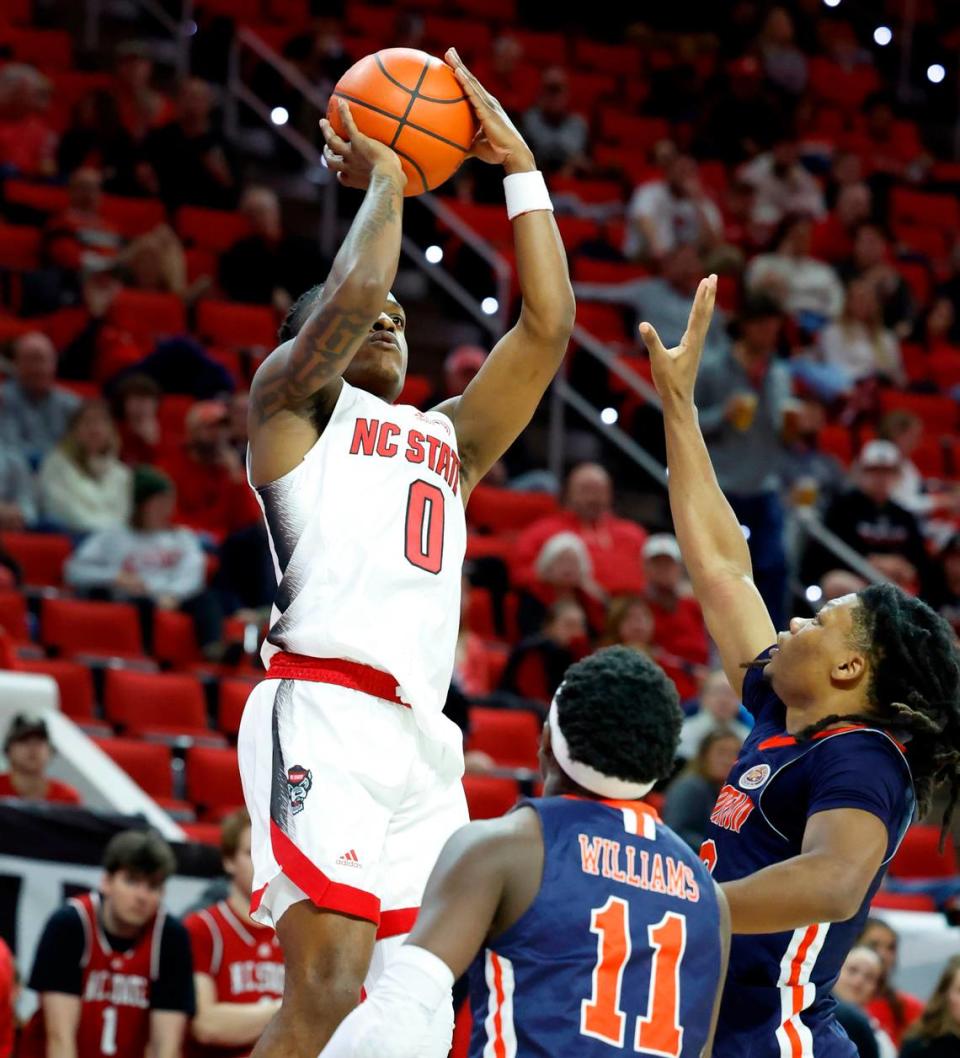N.C. State’s DJ Horne (0) shoots a three-pointer over the defense of UT Martin’s Desmond Williams (11) and Jordan Sears (3) during the second half of N.C. State’s 81-67 victory over UT Martin at PNC Arena in Raleigh, N.C., Tuesday, Dec. 12, 2023.