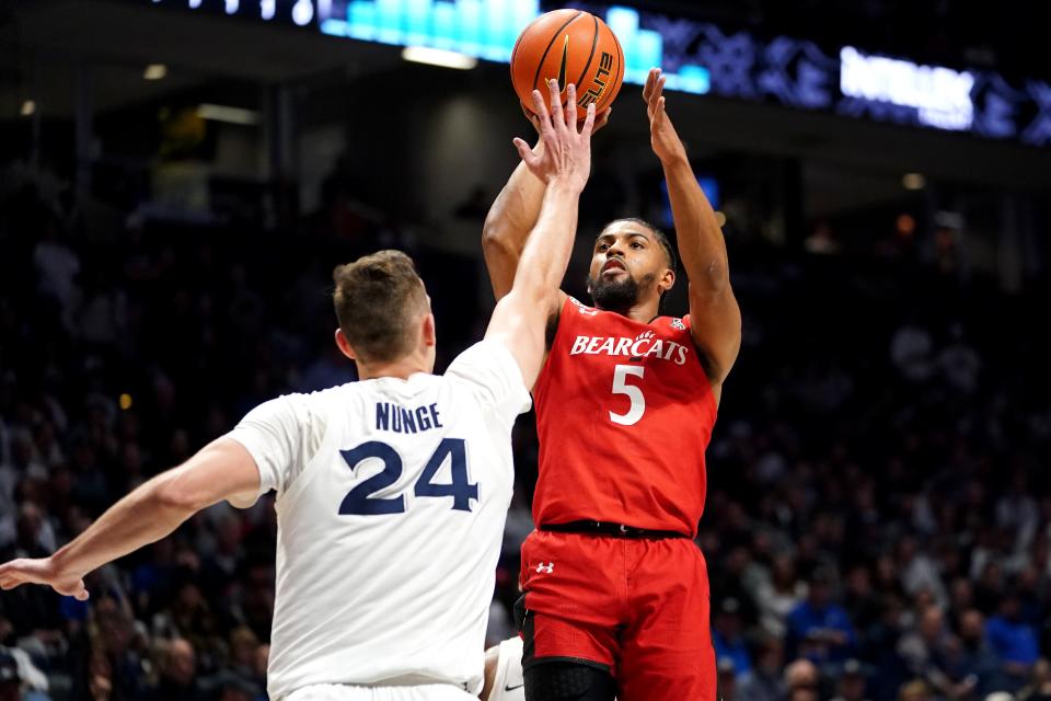 Cincinnati Bearcats guard David DeJulius (5) rises for a shot as Xavier Musketeers forward Jack Nunge (24) defends in the first half of the 89th Annual Crosstown Shootout college basketball game, Saturday, Dec. 11, 2021, at Cintas Center in Cincinnati. 