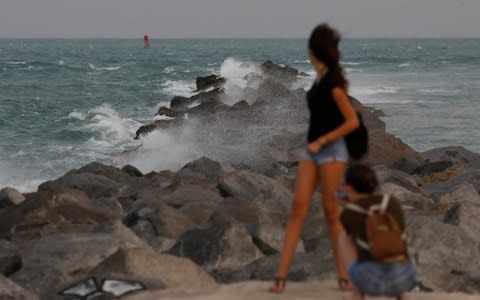 A tourist poses for a picture at a pier in South Beach prior to the arrival of Hurricane Irma to south Florida, in Miami, Florida - Credit: Reuters