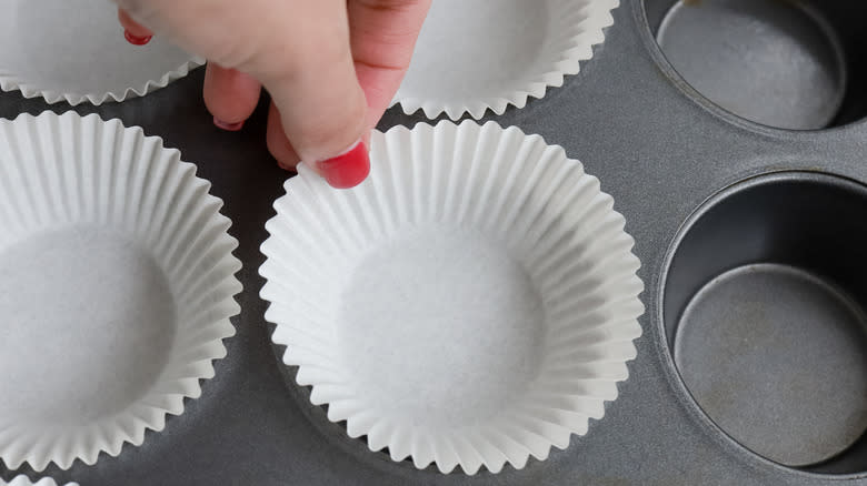 placing cupcake liners in pan