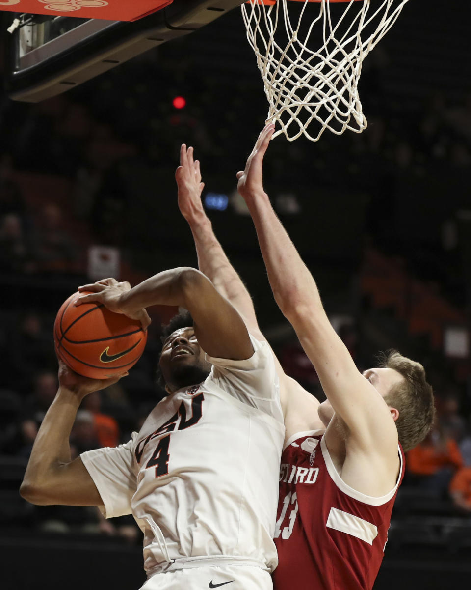 Oregon State guard Dexter Akanno (4) drives to the basket as Stanford guard Michael Jones (13) defends during the first half of an NCAA college basketball game in Corvallis, Ore., Thursday, March 2, 2023. (AP Photo/Amanda Loman)