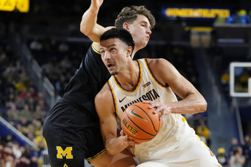 Minnesota forward Dawson Garcia (3) drives as Michigan forward Will Tschetter defends during the first half of an NCAA college basketball game, Thursday, Jan. 4, 2024, in Ann Arbor, Mich. (AP Photo/Carlos Osorio)